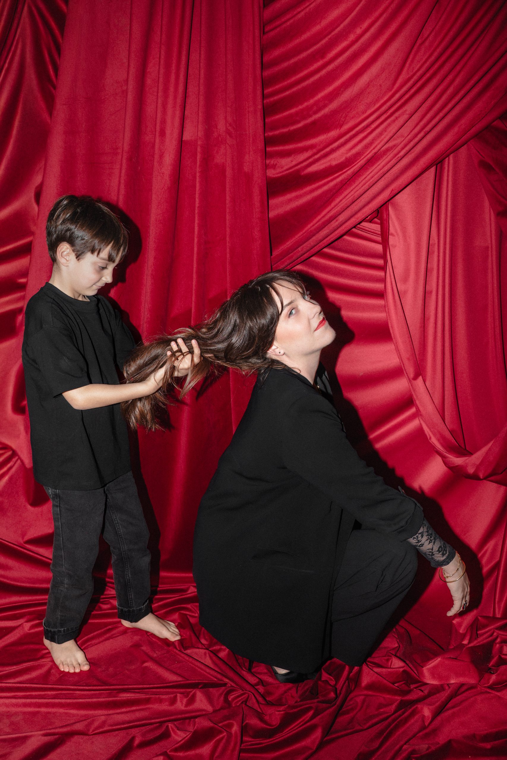 portrait mère et fils dans un studio photo maternité très moderne aux tons rouges 